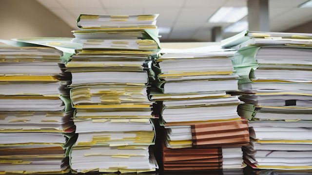 Pilas de expedientes y carpetas de papel en una oficina