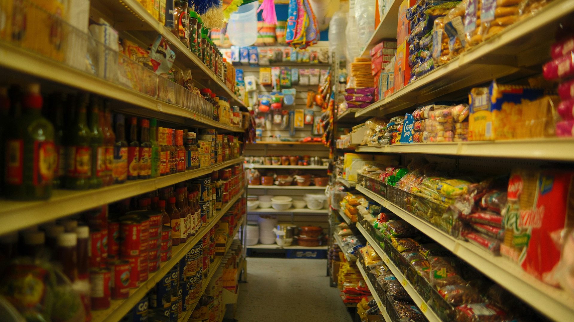 Pasillo de una tienda de abarrotes con anaqueles llenos de productos
