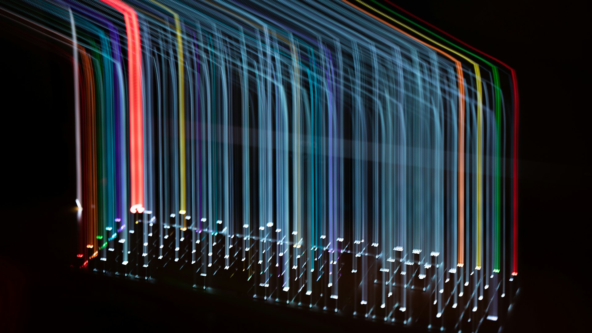 Trazos de luz de colores que forman barras sobre fondo negro